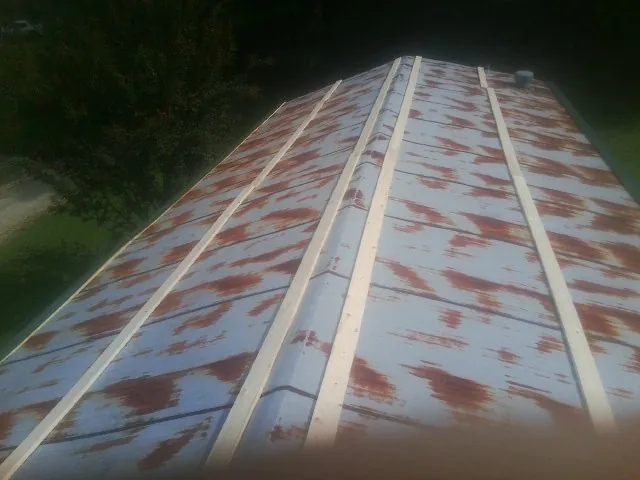 Rusted metal roof panels with new wood purlins before replacement — Storm Damage Roof Repair in Union Grove by Roofing Brothers